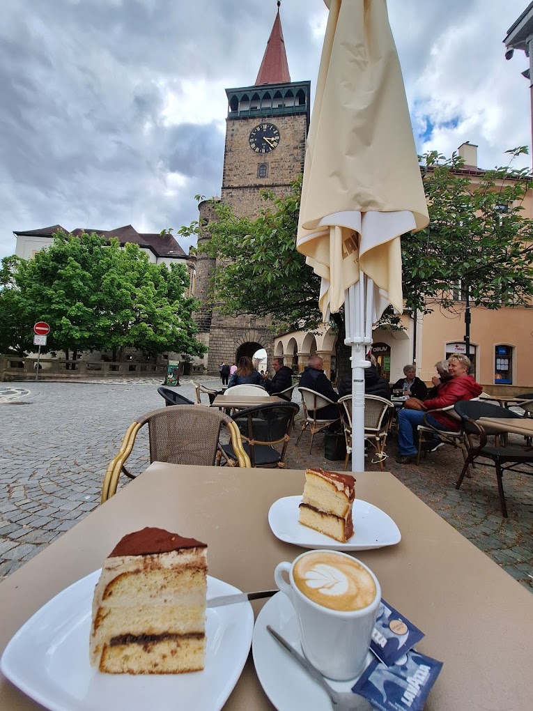 Posezení na terase s výhledem na Valdickou bránu, dort a cappuccino
